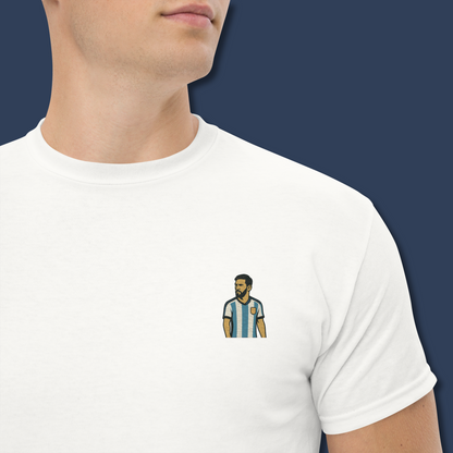 Men's (or Unisex) white cotton graphic tee featuring a small, retro-inspired embroidered patch/graphic of football player Lionel Messi in the Argentina (AFA) 'Albiceleste' jersey. GOAT, soccer, football, vintage style, Strength and Courage brand.