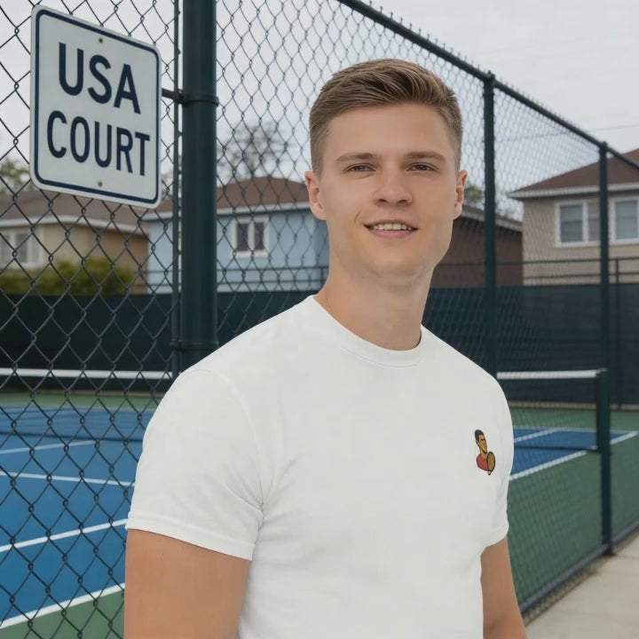 White cotton short sleeve t-shirt featuring a small, minimalist embroidered graphic design of tennis player Novak Djokovic in a red shirt holding a racket.